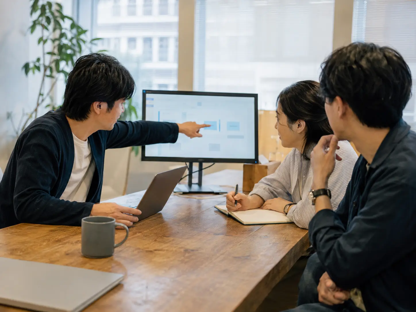 SaaSの管理画面を見ながら導入方法を検討するチーム(業界イメージ)
