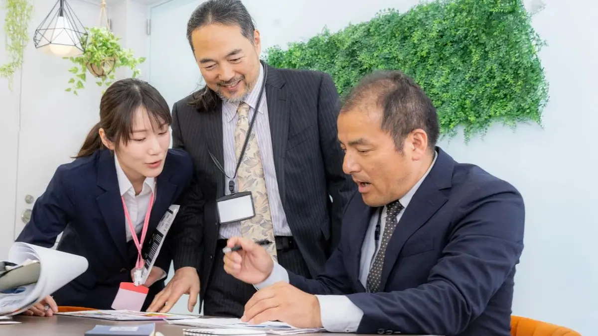 入社後の資料を確認する日本人社員と担当者（支援業種のイメージ）